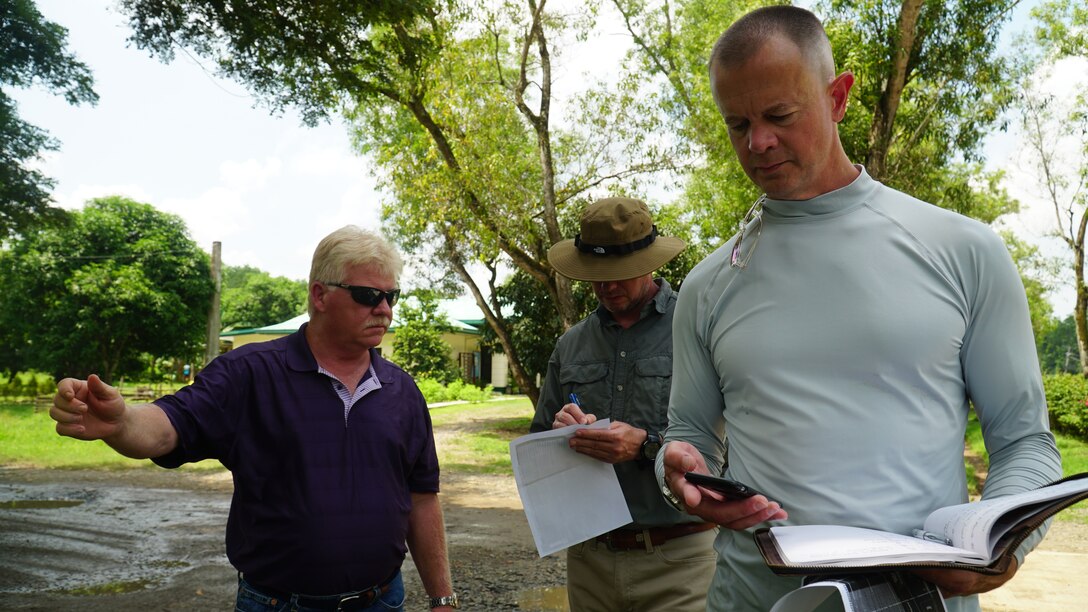 U.S. Army Corps of Engineers members, Rob Harmison, left, from the Pittsubrgh District, Michael Womack, center, from the Wilmington District, and Mike Diller from the Kansas District, orient themselves and discuss the proposed site plan at Fort Magsaysay in the Philippines on July 14, 2022. Harmison, Womack and Diller are part of USACE’s Forward Engineer Support Team-Advance Team based in Mobile, Alabama, were field training for an upcoming deployment. (Courtesy)