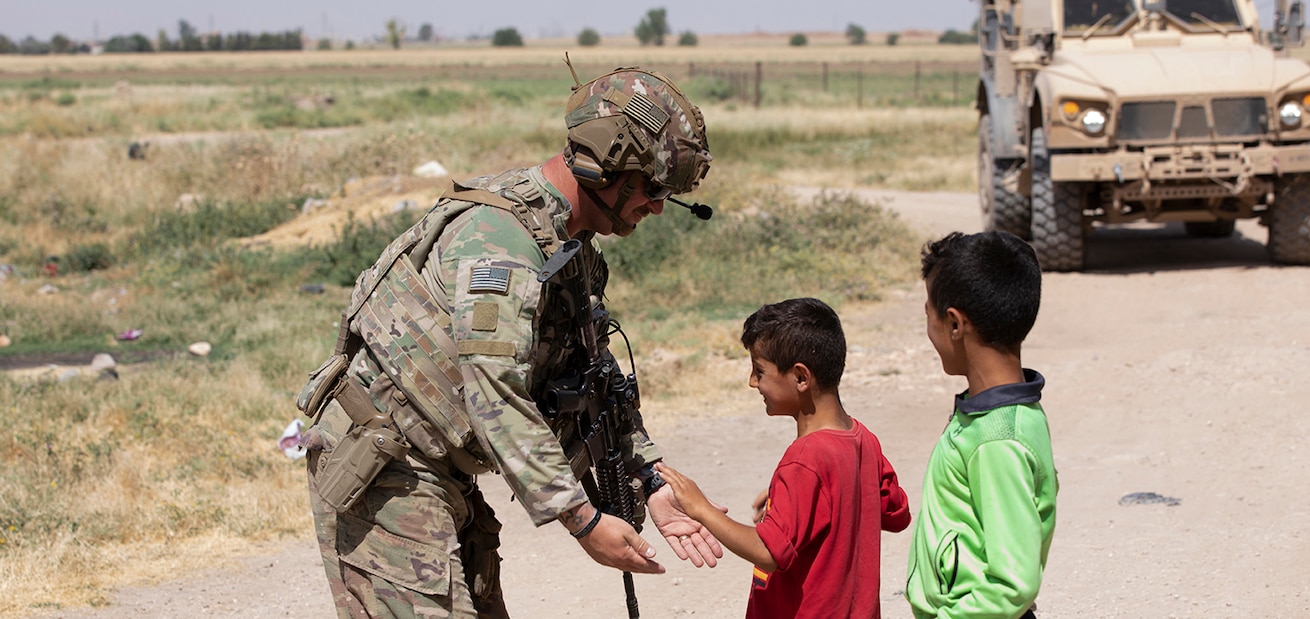 A U.S. Army Soldier assigned to Task Force Chosin interacts with local Syrian children during a partnered patrol with the Syrian Democratic Forces in North East Syria June 16, 2022. Combined Joint Task Force - Operation Inherent Resolve continues to advise, assist, and enable partner forces in designated areas of Syria to set conditions for long-term security. (U.S. Army photo by Cpl. Tommy L. Spitzer)