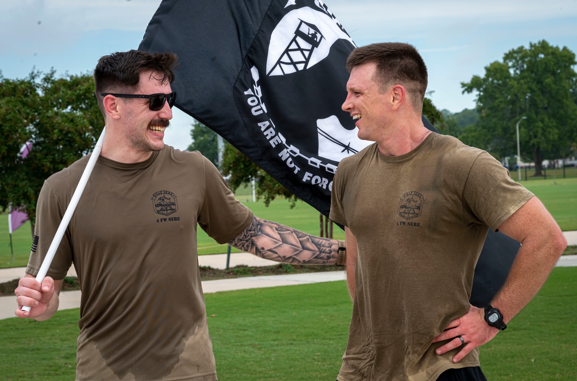 Senior Airman Mason Mark, 4th Civil Engineering Squadron operations manager, and Tech. Sgt. Alan Downs, 4th Operation Support Squadron survival, evasion, resistance and escape specialist, rests after a ruck march during POW/MIA Remembrance Week at Seymour Johnson Air Force Base, North Carolina, September 12, 2022. Airmen ran a total of eight miles with the POW/MIA flag from Seymour Johnson AFB to the Wayne Veteran Memorial. (U.S. Air Force photo by Airman 1st Class Sabrina Fuller)