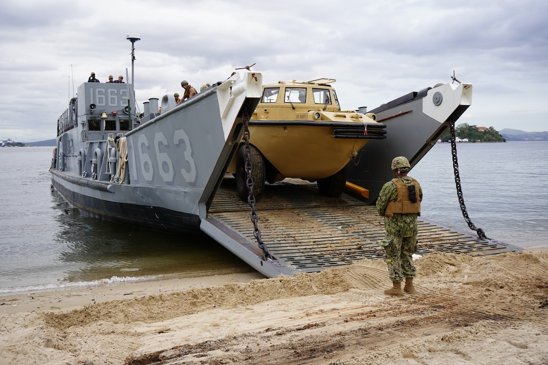 Chief Warrant Officer Michael Fifer, Officer-in-Charge of Command Beachmaster Unit (BMU) 2, Expeditionary Strike Group (ESG) 2, United States Navy, supervises the loading of a Light Amphibious Recovery Craft (LARC) aboard Landing Craft, Utility 1663, at Ilha do Governador, Rio de Janeiro, Sept. 6, 2022. UNITAS is the world's longest-running annual multinational maritime exercise that brings together forces from 19 countries to include Brazil, Cameroon, Chile, Colombia, Dominican Republic, Ecuador, France, Guyana, Jamaica, Mexico, Namibia, Panama, Paraguay, Peru, South Korea, Spain, the United Kingdom, the United States of America, and Uruguay. The exercise focuses on enhancing interoperability among multiple nations and joint forces during littoral and amphibious operations in order to build on existing regional partnerships and create new enduring relationships that promote peace, stability, and prosperity in the U.S. Southern Command’s area of responsibility. (U.S. Marine Corps photo by Maj. Jeremy Wheeler)