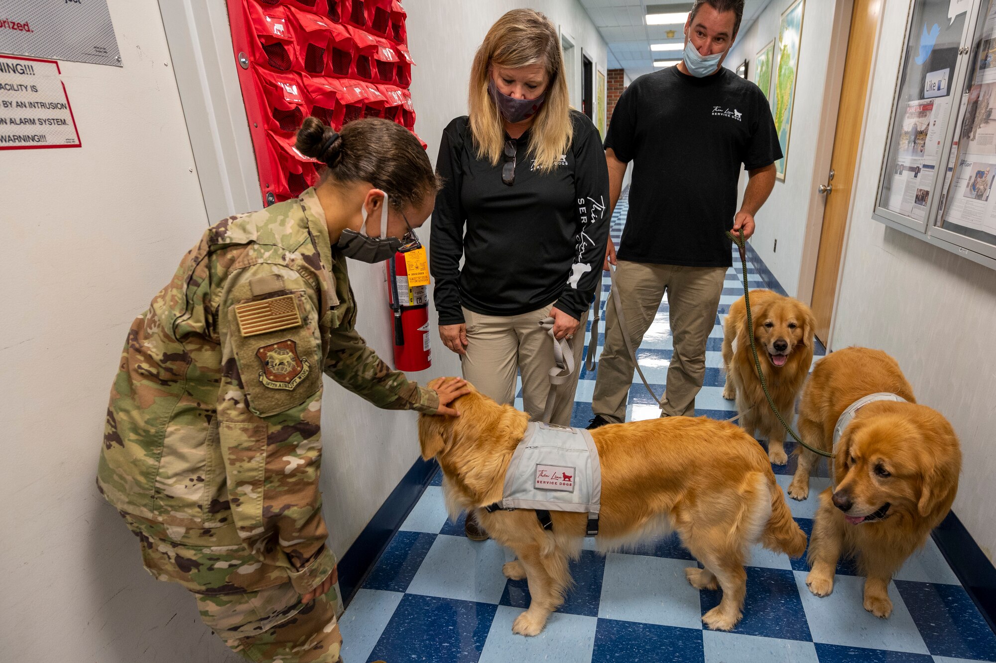U.S. Air Force Staff Sgt. Dominique Wright, a command and control specialist for the 167th Airlift Wing, is greeted by Thin Line Service Dogs, Moose, Chief and September, along with the organization’s founders Anjanette and Wayne Montano.