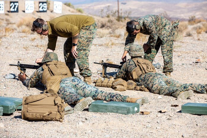 Sergeant Daniel Garcia, range safety officer, and Cpl. Christopher Garcia, combat marksmanship trainer, train Cpl. Zachary Gandiongco and Lance Cpl. Anthony Cashiola in proper rifle and scope use during live fire training held at the range aboard Marine Corps Logistics Base Barstow, California, September 14.