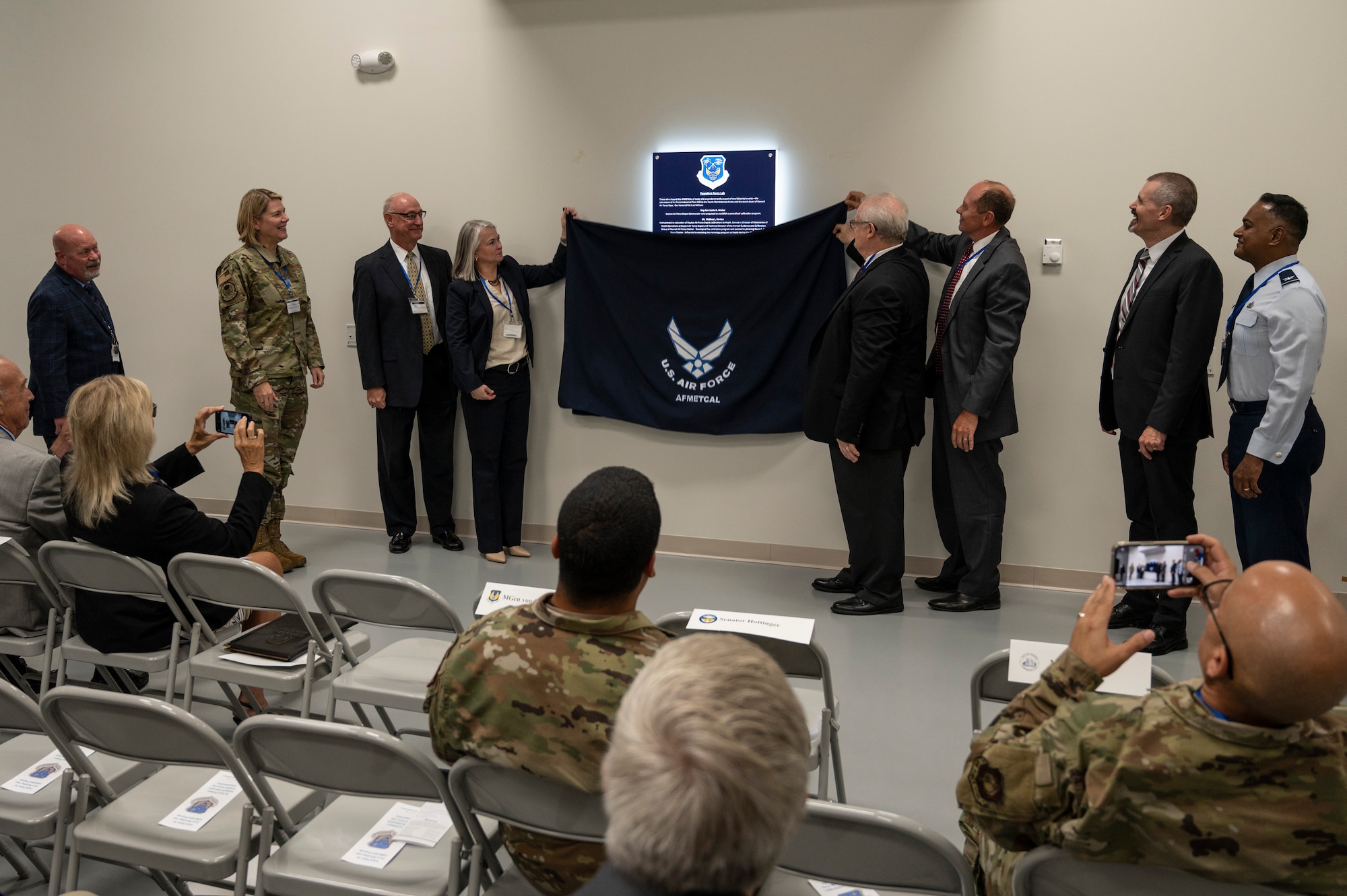 Guests of honor unveil a placard at a commemoration ceremony at the Air Force Primary Standards Lab at Heath, Ohio Sept. 12, 2022.