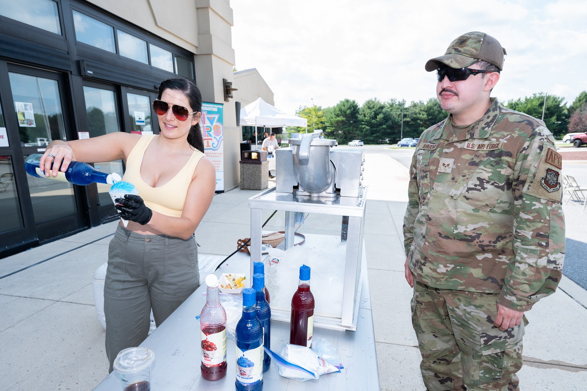 Tech. Sgt. Alicia Garcia, 436th Force Support Squadron Airman Leadership School commandant, serves snow cones at the Hispanic Heritage Month Block Party on Dover Air Force Base, Delaware, Sept. 15, 2022. The annual event kicks off a series of events on Dover AFB that celebrate Hispanic Heritage Month. (U.S. Air Force photo by Mauricio Campino)
