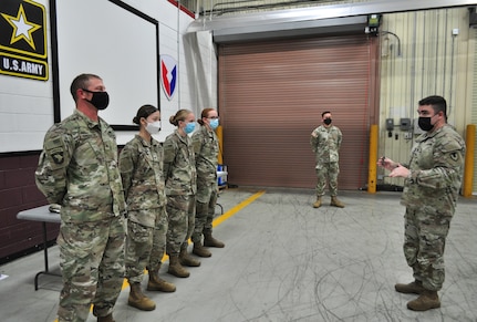 Lt. Col. Mark Sander, right, commander of the U.S. Army Medical Materiel Center-Korea, presents USAMMC-K coins to reserve Soldiers from the 401st Medical Logistics Company following training in August during Ulchi Freedom Shield, a joint exercise with Korean forces.