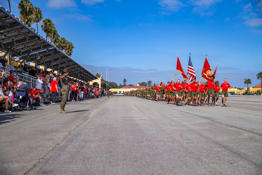 Marine carrying flags run in formation.