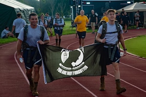 Airman assigned to the 6th Air Refueling Wing carry the prisoner-of-war/missing in action flag during the POW/MIA 24-hour run at MacDill Air Force Base, Florida, Sept 16, 2022. The POW/MIA flag was adopted in 1972. It was then enshrined into law as mandatory to be flown on federal properties in 2019. (U.S. Air Force photo by Airman 1st Class Michael Killian)