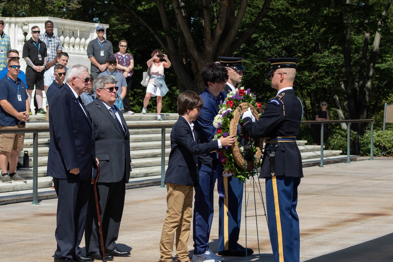 Uniformed service members and civilians participate in placing a wreath.