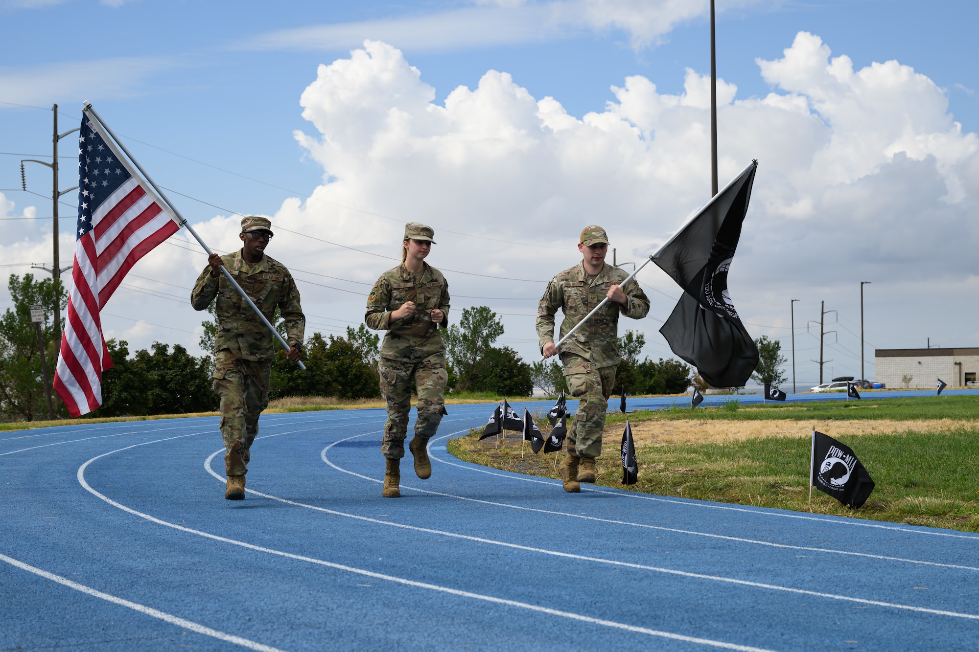 Left to right, Senior Airman Donald Lamar, Airman 1st Class Ella Valley, and Airman 1st Class Matthew Taylor, 75th Medical Group, run the POW/MIA flag around the base track during a POW/MIA Remembrance Week event at Hill Air Force Base, Utah, Sept. 15, 2022.
