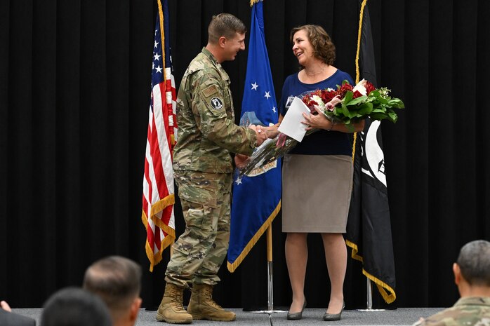 Tech. Sgt. Brian Nichols, 348th Recruiting Squadron, presents Stephanie Galley with a gift during Team Hill's POW/MIA Remembrance Week closing ceremony at Hill Air Force Base, Utah, Sept. 16 2022.