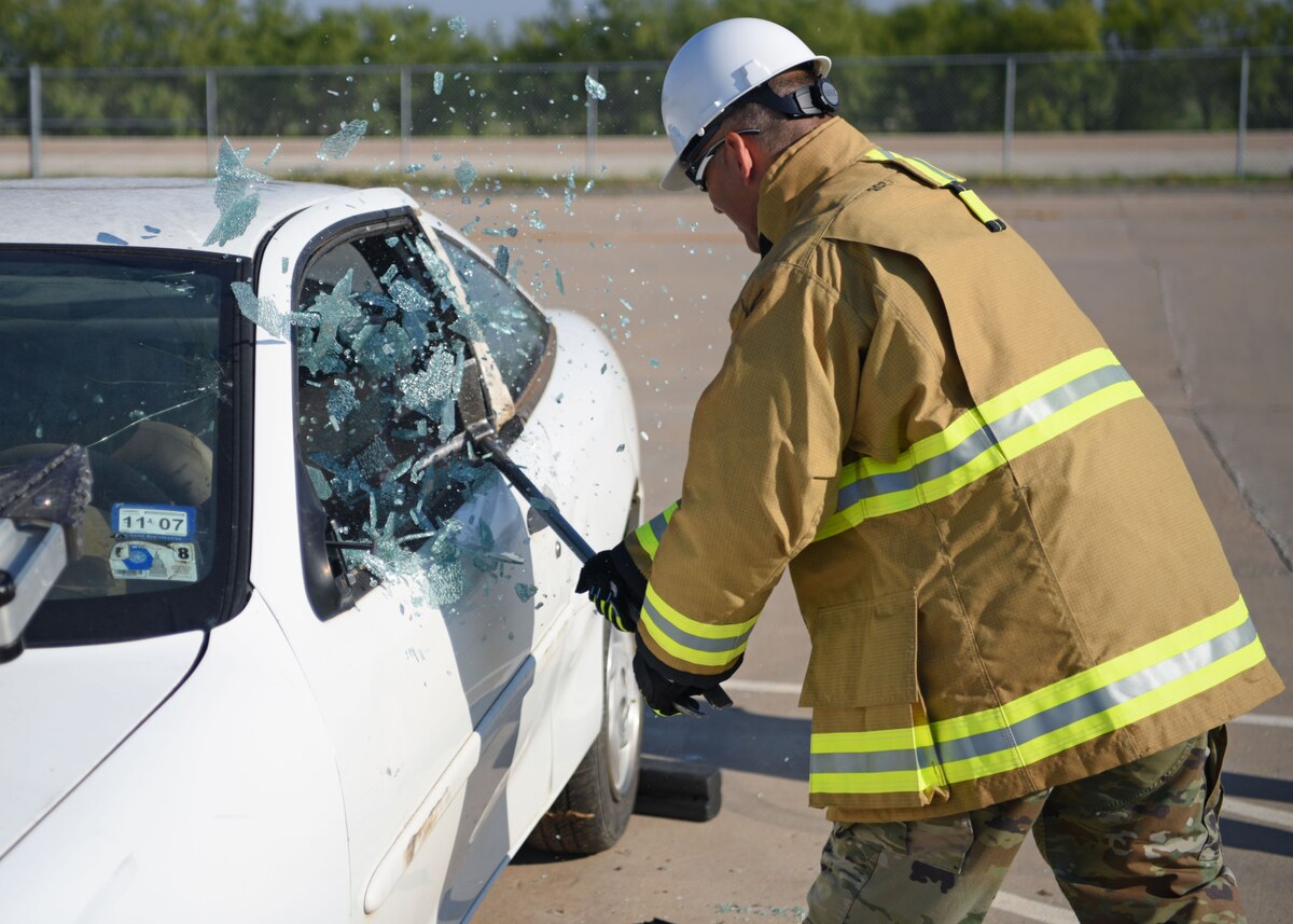 U.S. Air Force Col. Nicholas Dipoma, Second Air Force vice commander, smashes a window during vehicle extraction training at the Louis F. Garland Department of Defense Fire Academy, Goodfellow Air Force Base, Texas, Sept. 14, 2022. DoD fire protection students successfully complete several blocks of instruction before graduating from the academy, covering everything from fighting aircraft fires to medical procedures. (U.S. Air Force photo by Senior Airman Ethan Sherwood)