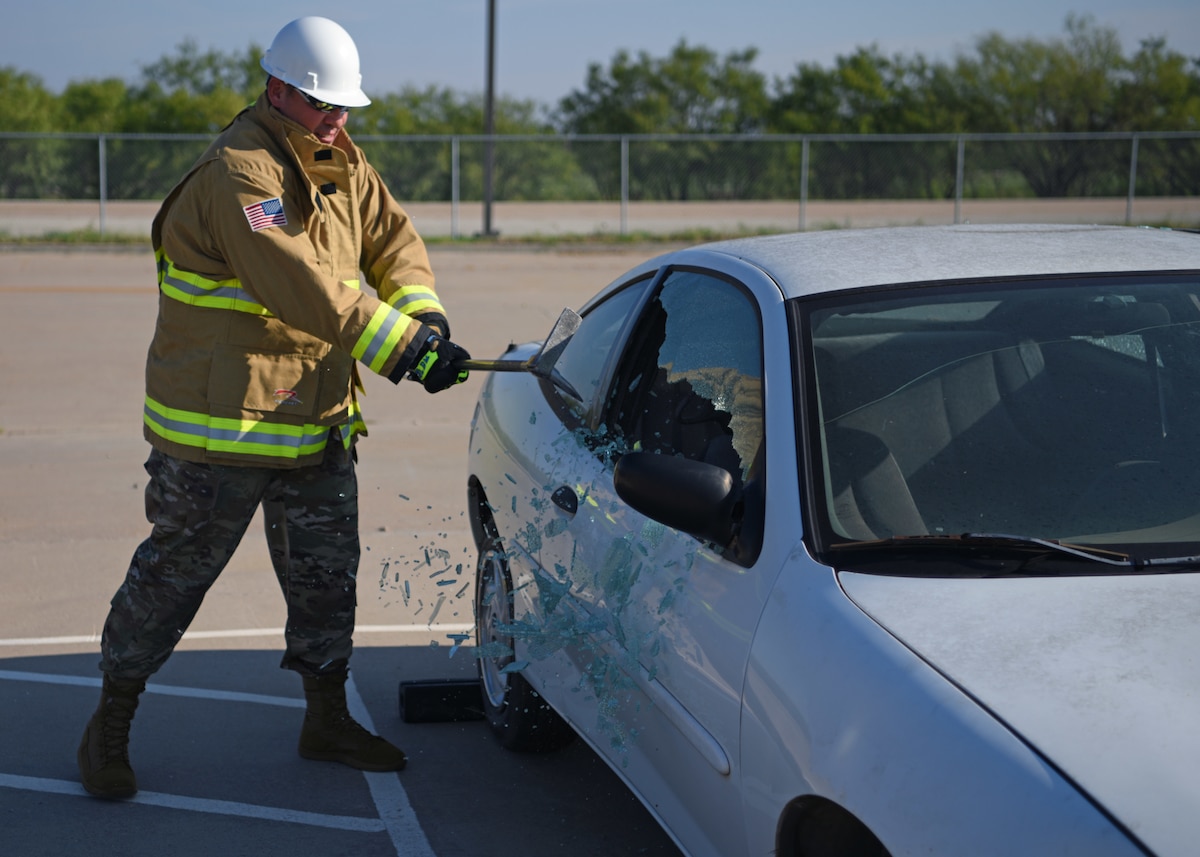 U.S. Air Force Maj. Richard Cordova, Second Air Force A9, shatters a window during vehicle extraction training at the Louis F. Garland Department of Defense Fire Academy, Goodfellow Air Force Base, Texas, Sept. 14, 2022. Cordova was shown how students train for emergency situations by members of the 312th Training Squadron. (U.S. Air Force photo by Senior Airman Ethan Sherwood)
