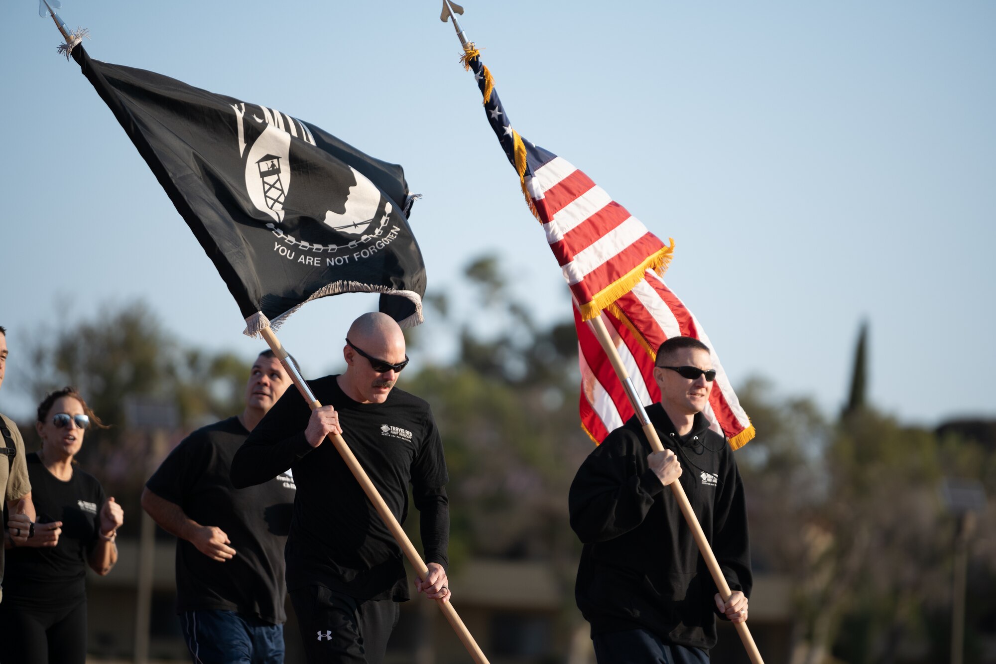 Airmen running with POW MIA flag and US flag