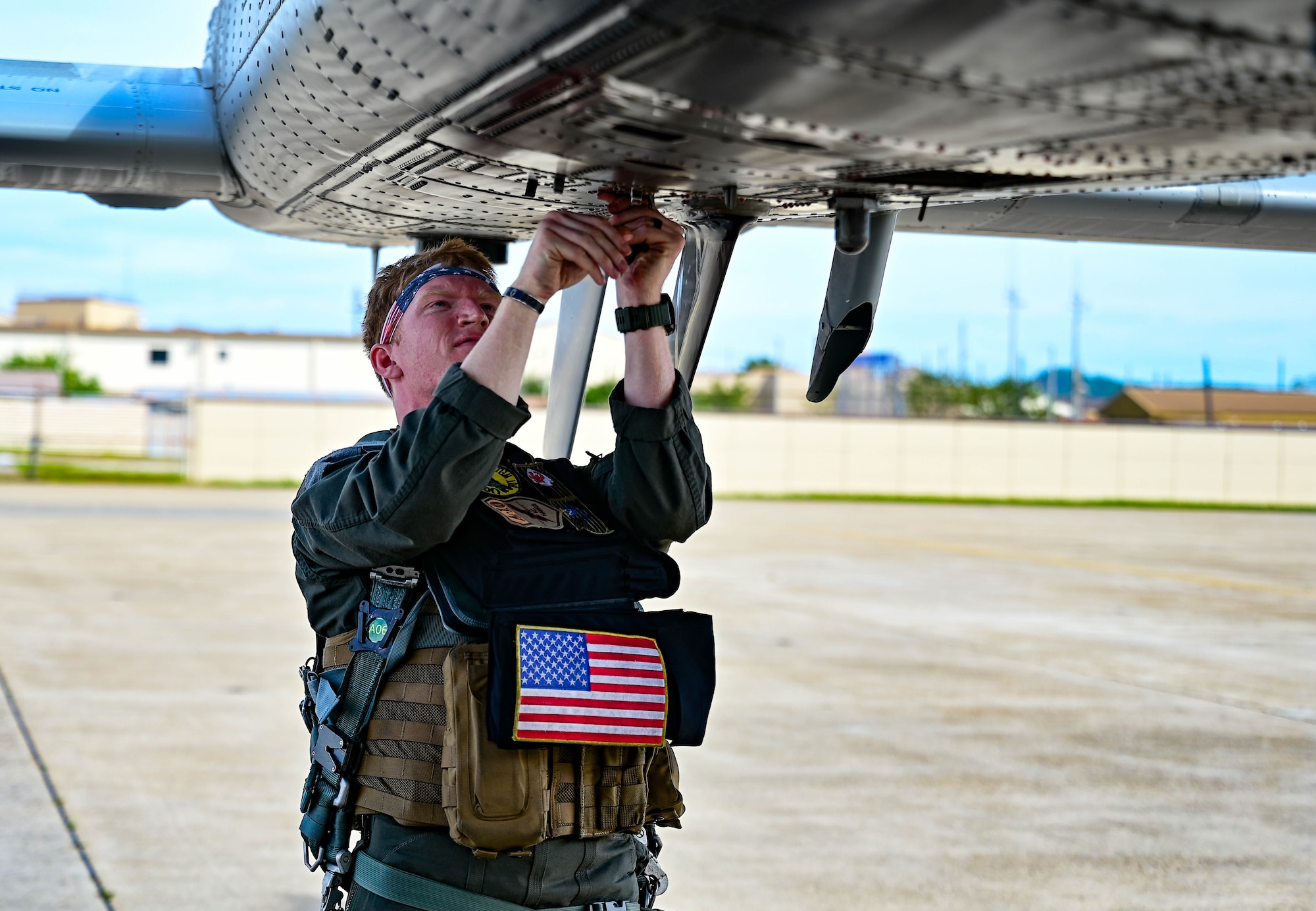 Pilot closing bottom hatch under aircraft.