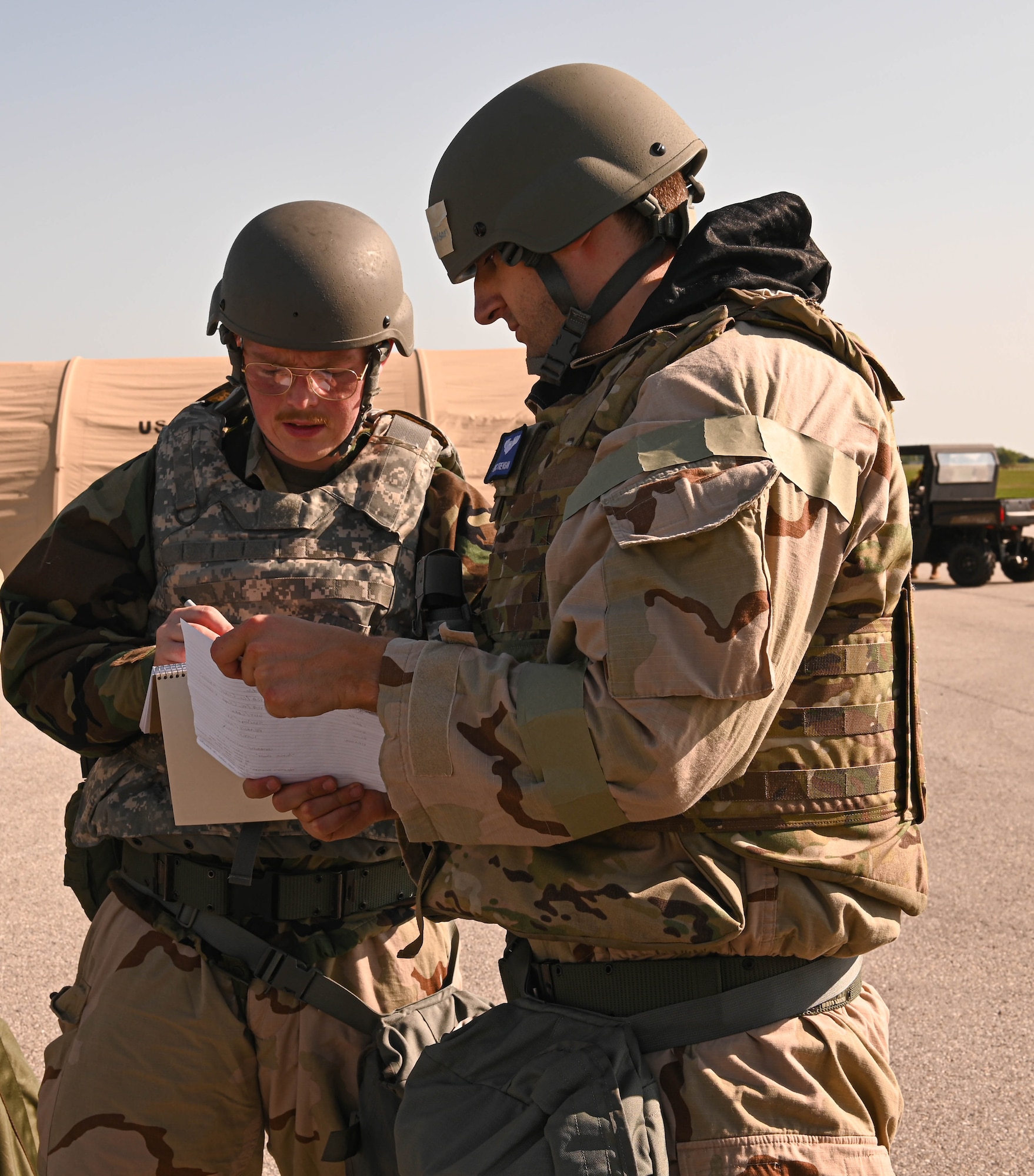 U.S. Air Force Airmen discuss specific details about the CBRN exercise at Whiteman Air Force Base, Missouri, September 15, 2022. This specific CBRN exercise spans across three days and includes a day of preparation before the simulated CBRN-contaminated environment. During the day of preparation Airmen attend an intel brief, pick up their MOPP gear, and receive refresher training. (U.S. Air Force photo by Airman 1st Class Hailey Farrell)