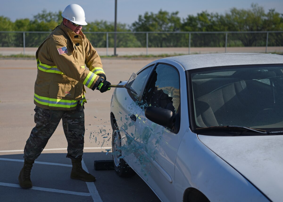 U.S. Air Force Maj. Richard Cordova, Second Air Force A9, shatters a window during vehicle extraction training at the Louis F. Garland Department of Defense Fire Academy, Goodfellow Air Force Base, Texas, Sept. 14, 2022. Cordova was shown how students train for emergency situations by members of the 312th Training Squadron. (U.S. Air Force photo by Senior Airman Ethan Sherwood)