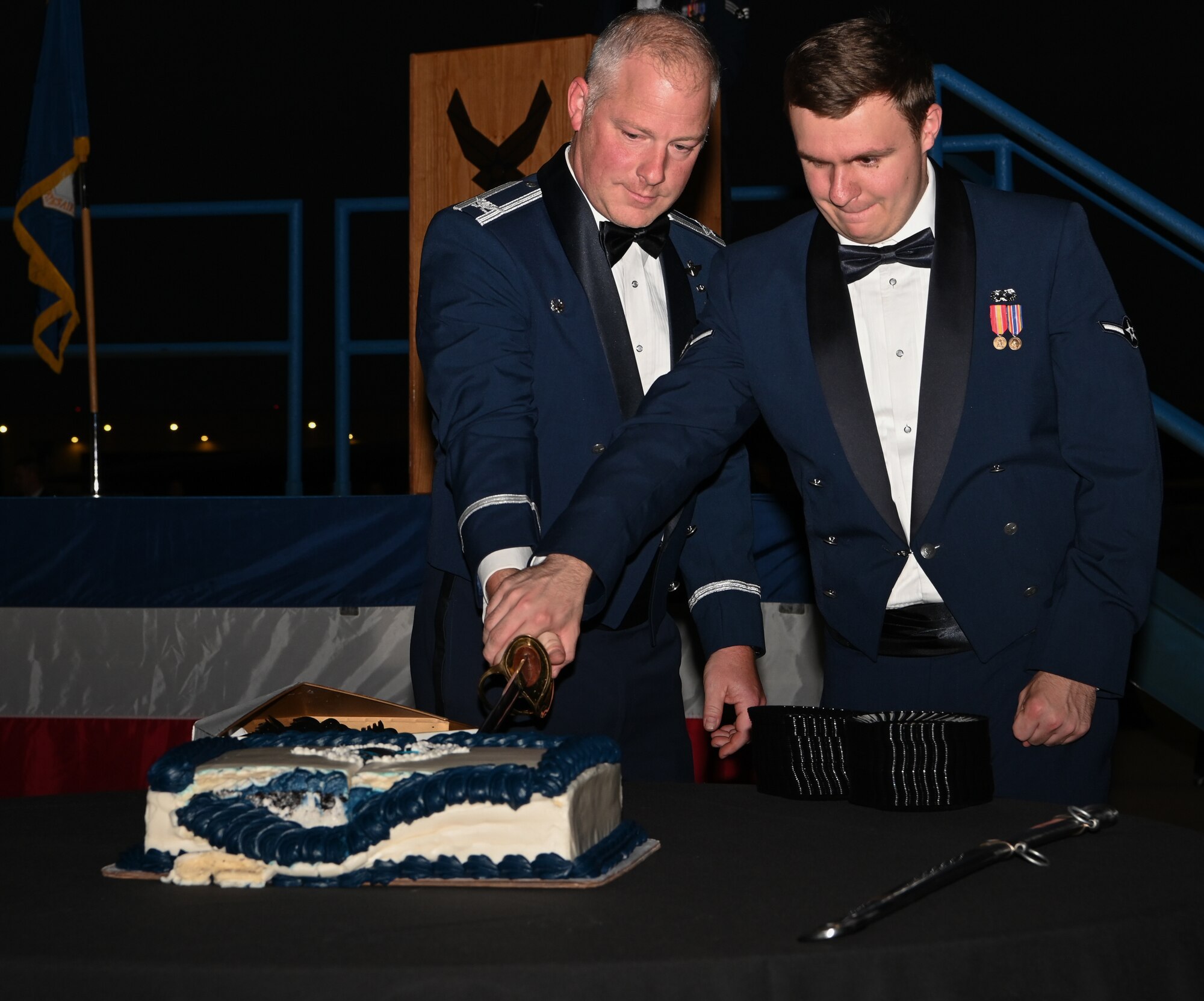 Col. Daniel Diehl, 509th Bomb Wing commander, helps cute the cake at the Air Force Ball at Whiteman Air Force Base, Missouri, September 16, 2022. The cake cutting ceremony celebrates the 75th Birthday of the U.S. Air Force, being tradition to cut it with a saber. (U.S. Air Force photo by Airman 1st Class Joseph Garcia)