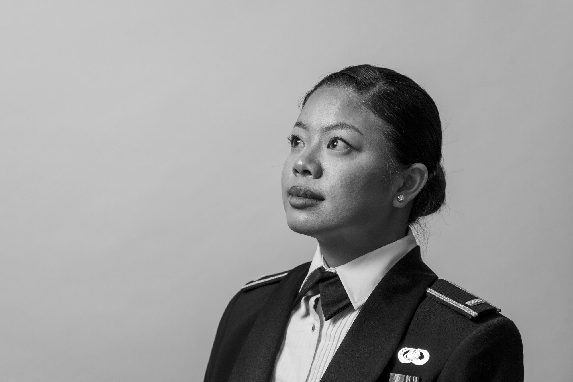 A woman in a ceremonial military uniform stands in front of a white background.