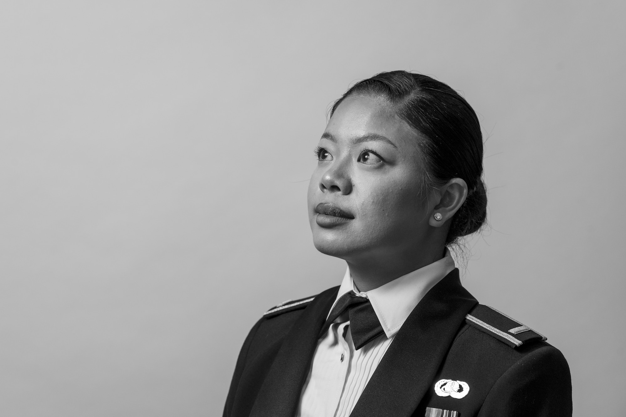 A woman in a ceremonial military uniform stands in front of a white background.