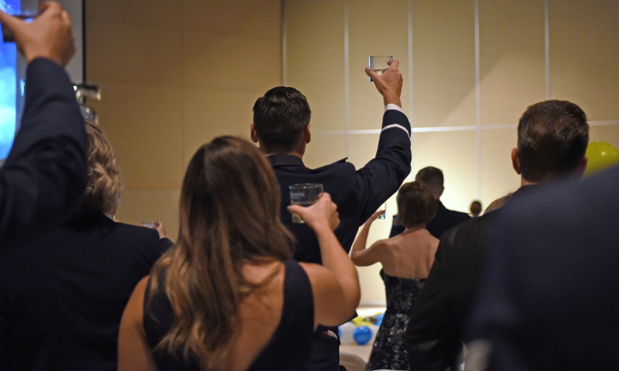 Members assigned to the 17th Training Wing raise glasses of water to the POW/MIA table at the McNease Convention Center, in San Angelo, Texas, Sept. 17, 2022. A POW/MIA table was displayed as a symbol of honor and to remember America’s prisoners of war and missing comrades. (U.S. Air Force photo by Senior Airman Abbey Rieves)