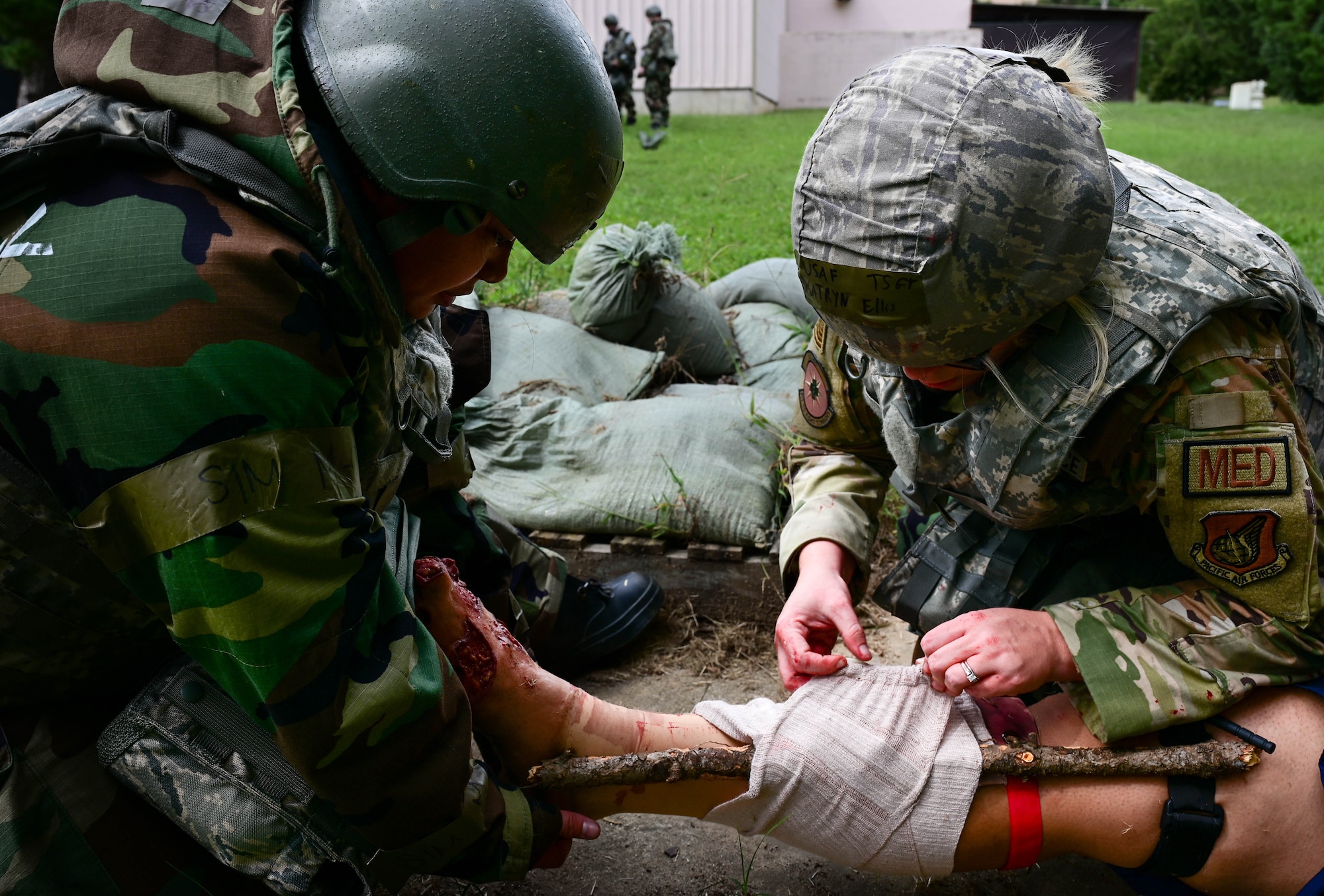 Airmen splint a leg with improvised tools.