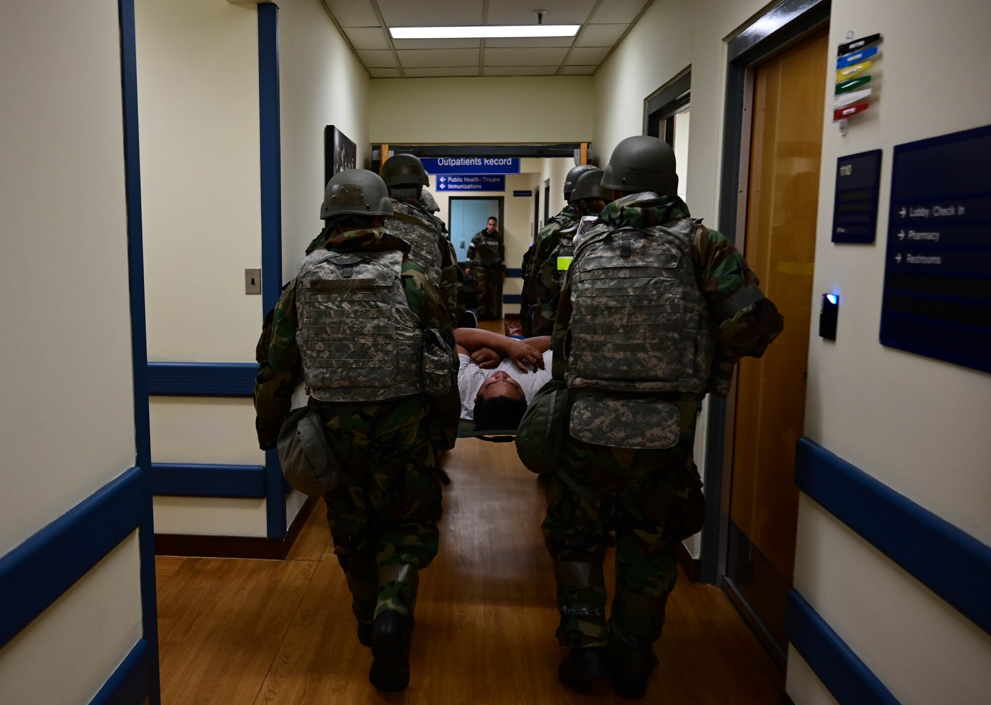 Airmen carrying a litter through a hallway.