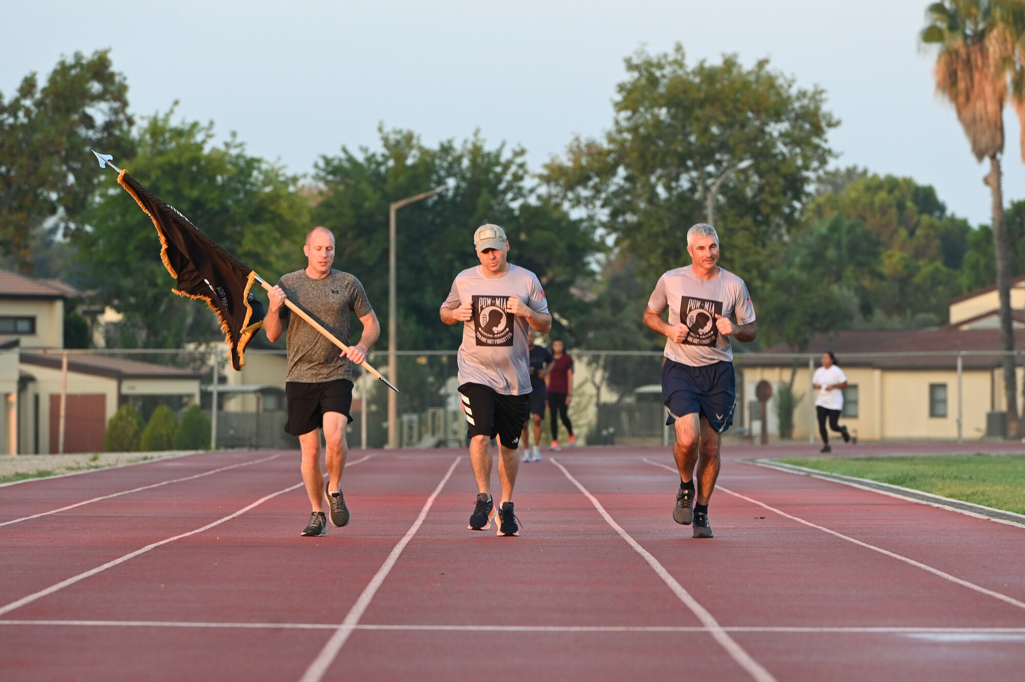 Three people run on a track.