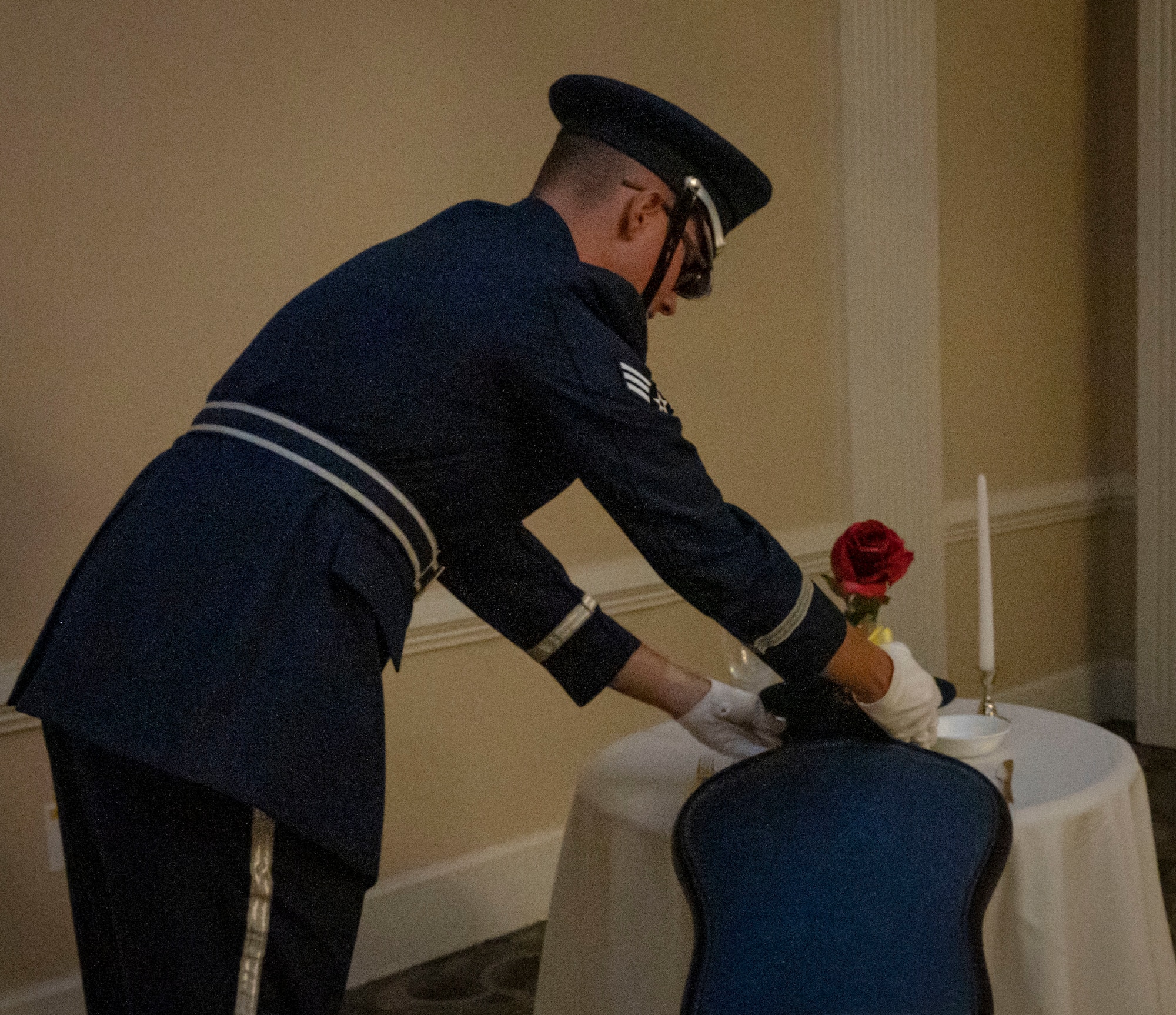 Senior Airman Noah Smith, 4th Equipment Maintenance Squadron aircraft structural maintainer and honor guard member, places a cover on a table in honor of Prisoner of War and Missing in Action personnel during the annual Air Force ball at Seymour Johnson Air Force Base, North Carolina, September 17, 2022. The event included a POW/MIA remembrance ceremony, formal toasts and a ceremonial cake cutting. (U.S. Air Force photo by Airman 1st Class Sabrina Fuller)