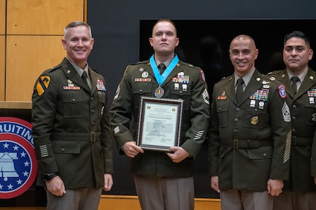 three people wearing U.S. army uniforms posed on a stage accepting awards.