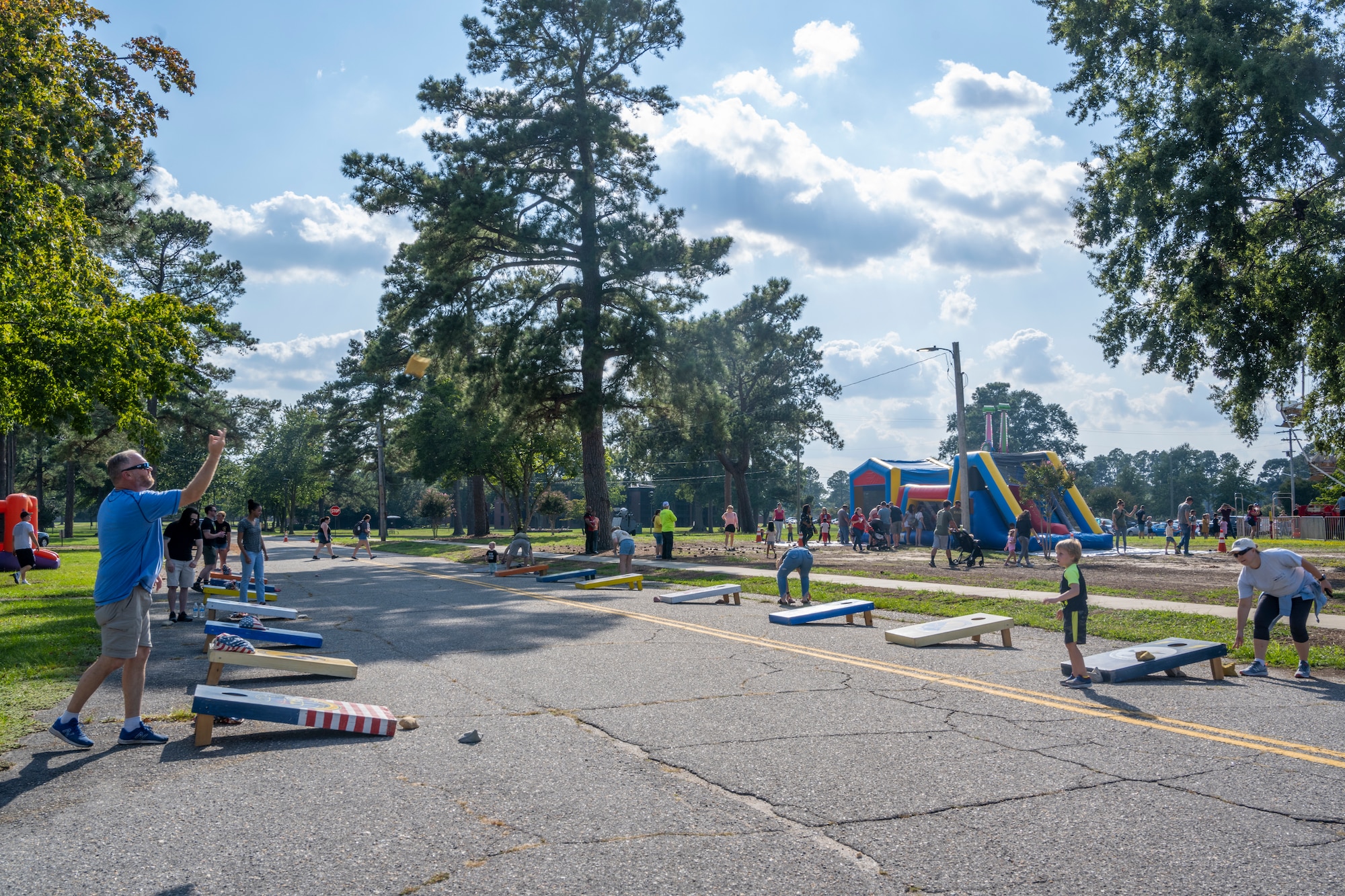 Families play cornhole during the Air Force Birthday Bash at Seymour Johnson Air Force Base, North Carolina, Sept. 16, 2022. The event was held in honor of the 75th Air Force Birthday, which included food stands, rides, games, live music and vendors for Airmen and their families to enjoy. (U.S. Air Force photo by Senior Airman Kylie Barrow)