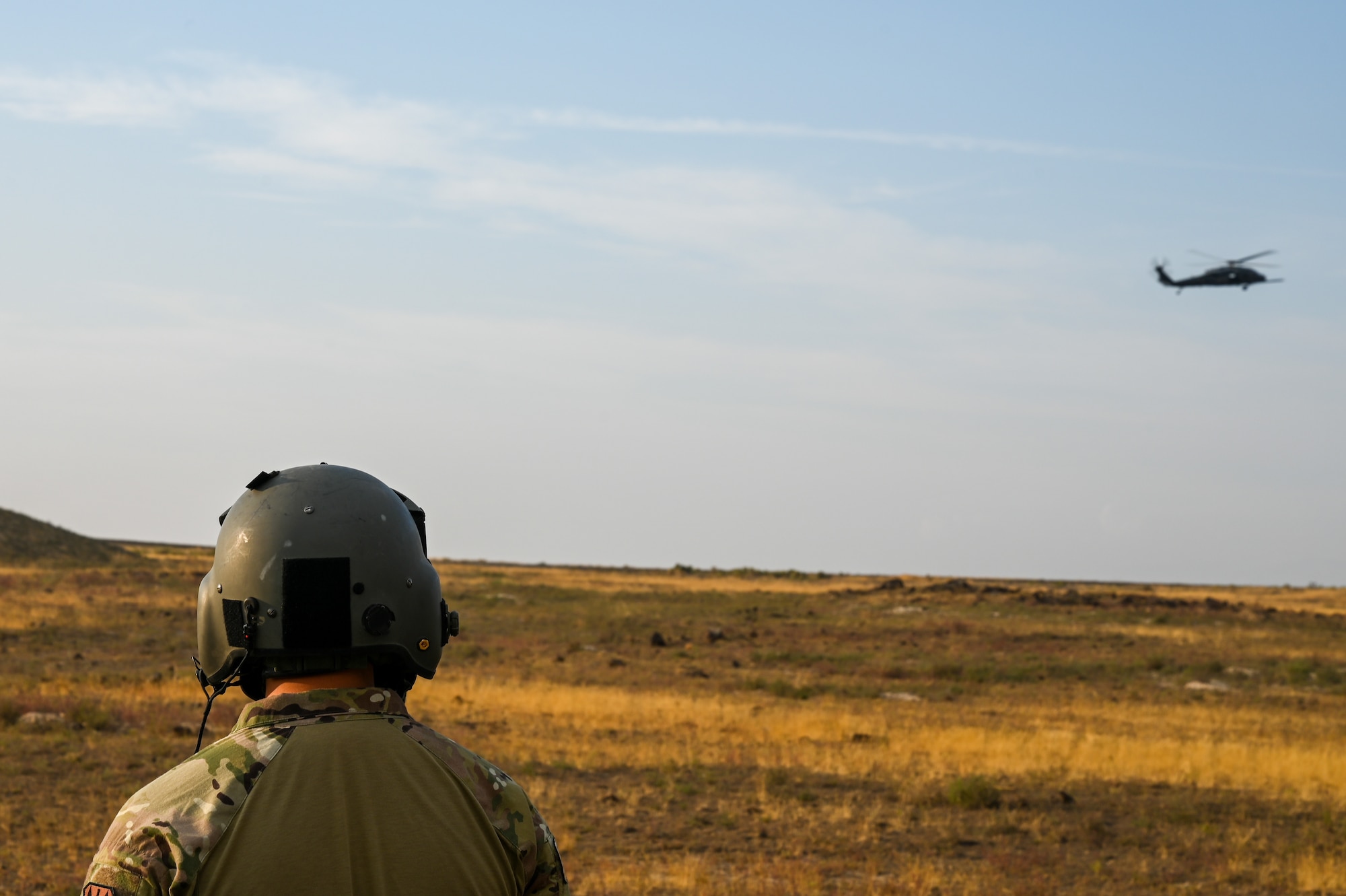 A photo of an Airman looking at an HH-60G Pavehawk.