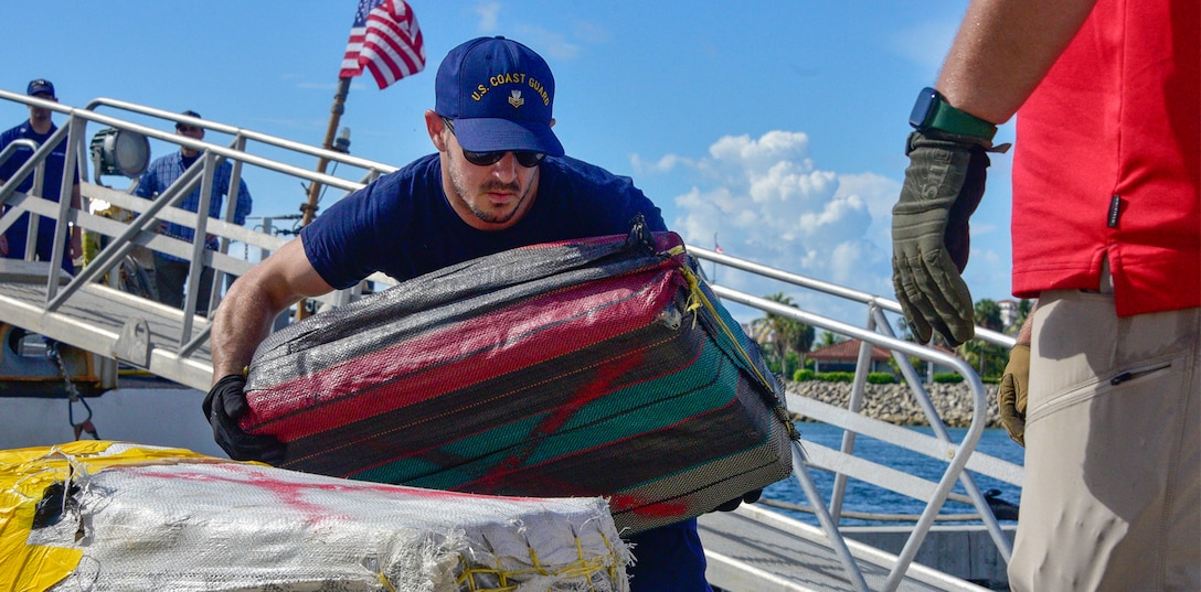 Bales of illegal drugs, worth an estimated $475 million, are offloaded onto pallets.