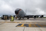 U.S. Air Force Airmen from the 18th Operations Group, 718th Aircraft Maintenance Unit and 18th Logistic Readiness Squadron watch as a 909th Air Refueling Squadron KC-135 Stratotanker is hot pit refueled for the first time in the Pacific at Kadena Air Base, Japan, March 22, 2022. Members of the 18th LRS fuels operate an R-11 refueling truck while 718th AMU members safely refuel aircraft. (U.S. Air Force photo by Airman 1st Class Cesar J. Navarro)