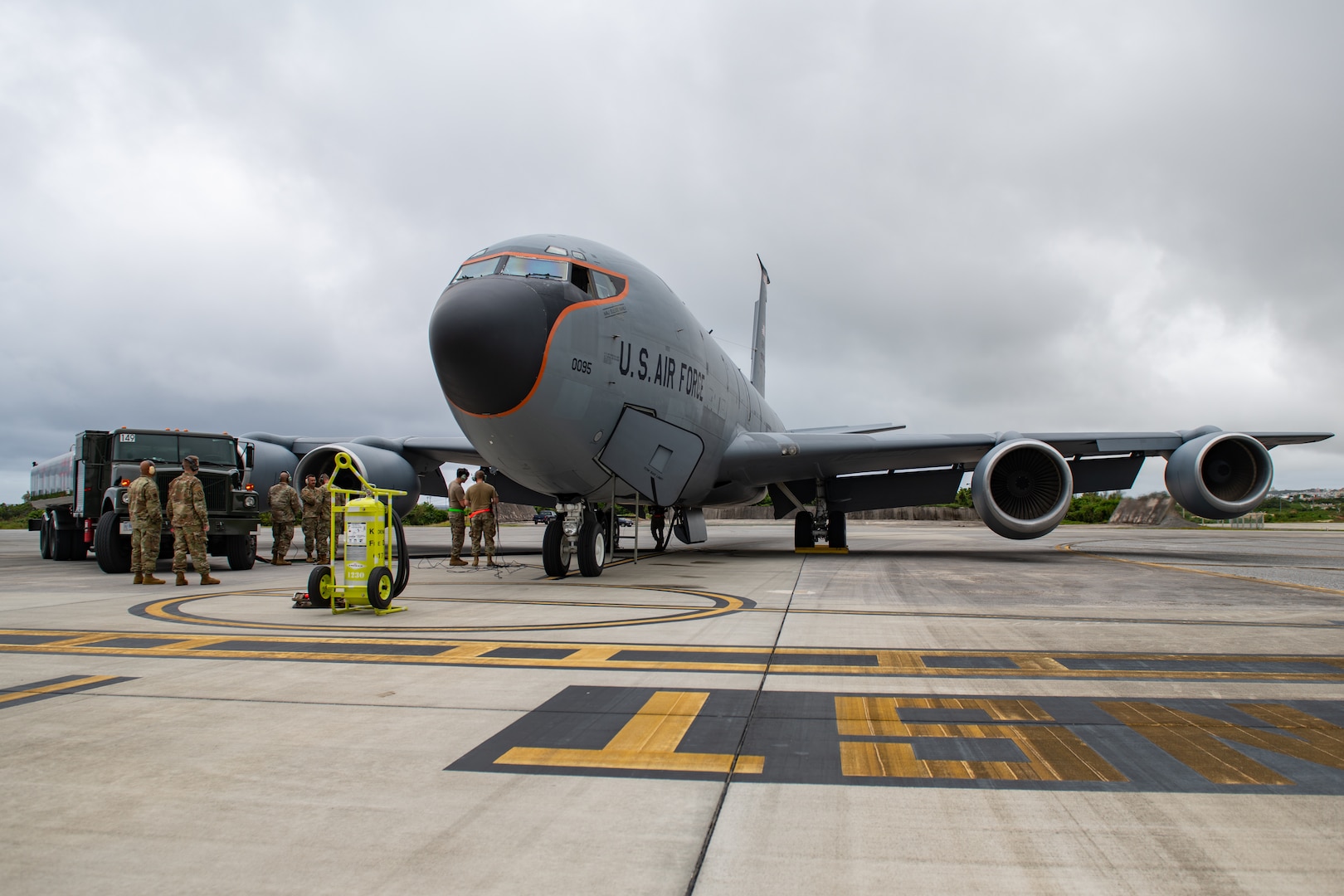 U.S. Air Force Airmen from the 18th Operations Group, 718th Aircraft Maintenance Unit and 18th Logistic Readiness Squadron watch as a 909th Air Refueling Squadron KC-135 Stratotanker is hot pit refueled for the first time in the Pacific at Kadena Air Base, Japan, March 22, 2022. Members of the 18th LRS fuels operate an R-11 refueling truck while 718th AMU members safely refuel aircraft. (U.S. Air Force photo by Airman 1st Class Cesar J. Navarro)