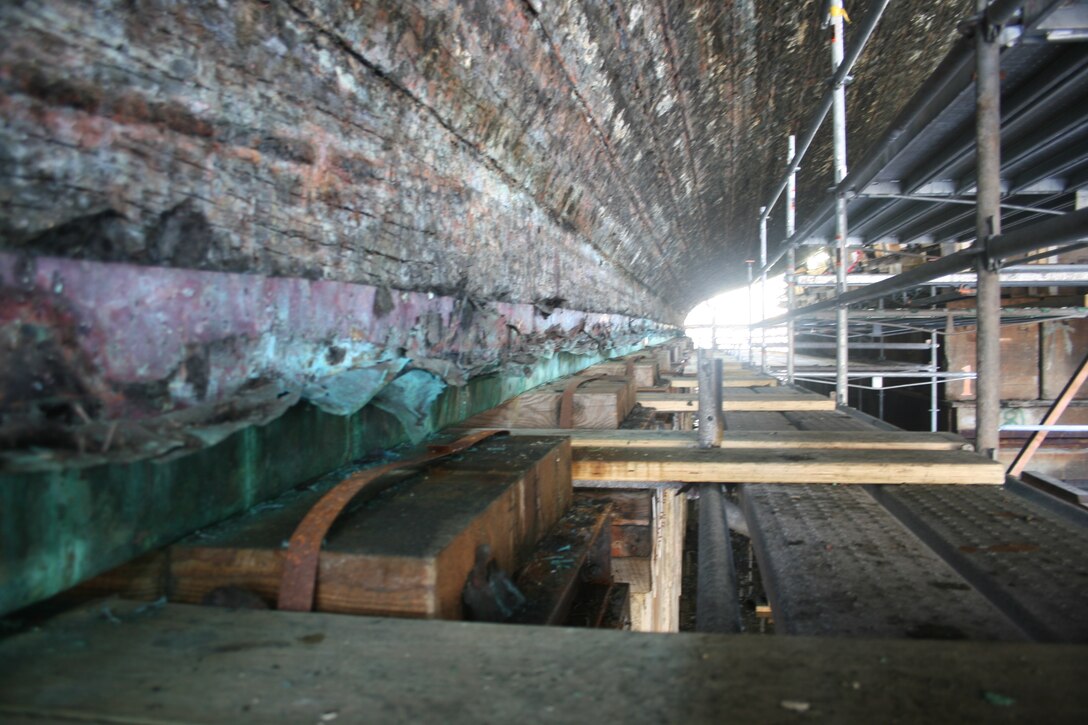 USS Constitution’s 1795 white oak keel, exposed during the ship’s 2015-2017 dry docking. Today, the ship’s below-the-waterline copper sheathing is replaced approximately every twenty years; the copper sheathing in the photo covers the false keel which is a protective wooden layer for the bottom of the keel. The dark angled line upper left is one of the keel’s four, twelve-foot scarf joints. Margherita M. Desy, Naval History & Heritage Command Detachment Boston