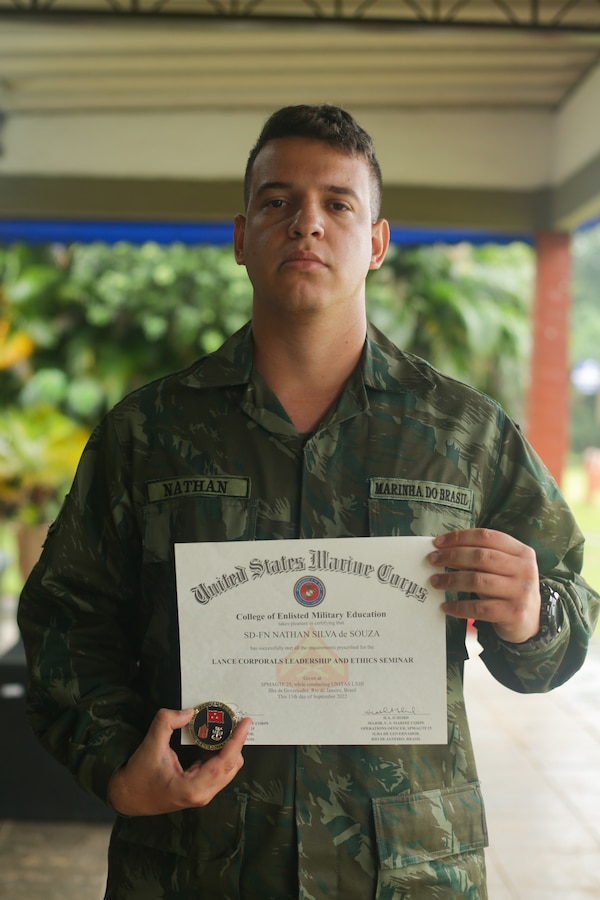 A Brazilian Marine holds his U.S. Marine Corps Lance Corporal Seminar graduation certificate and challenge coin that he received from U.S. Marine Corps Lt. Gen. David G. Bellon, commander of U.S. Marine Corps Forces, South and Marine Forces Reserve, during exercise UNITAS LXIII in Rio de Janeiro, Sept. 16, 2022. UNITAS is the world’s longest-running annual multinational maritime exercise that focuses on enhancing interoperability among multiple nations and joint forces during littoral and amphibious operations in order to build on existing regional partnerships and create new enduring relationships that promote peace, stability, and prosperity in the U.S. Southern Command’s area of responsibility. (U.S. Marine Corps photo by Cpl. Ethan Craw)