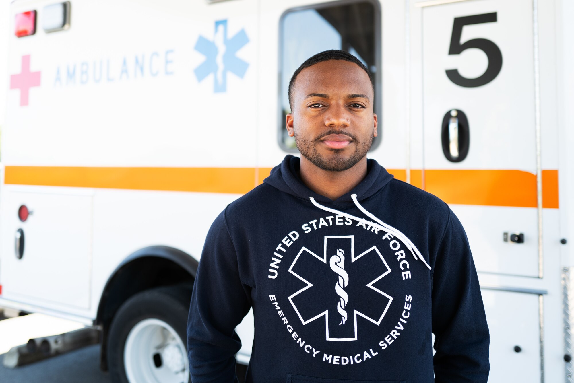 Airman standing in front of an ambulance