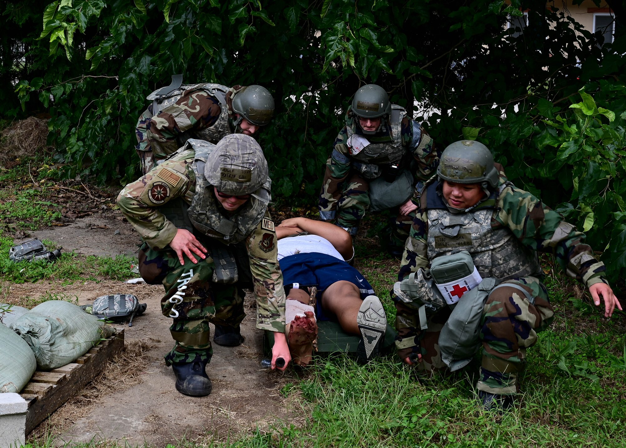 Airmen prepare to lift a litter.