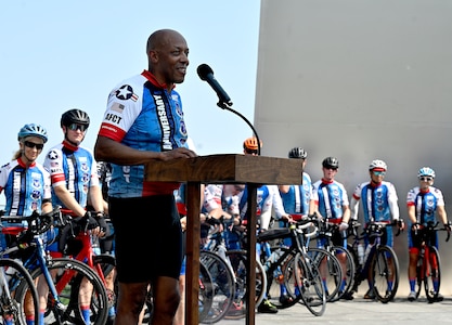 male cyclist speak to a group of cyclists