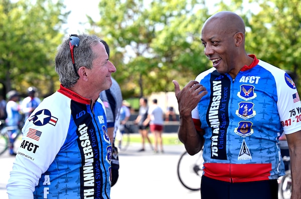 two male cyclists speak to one another