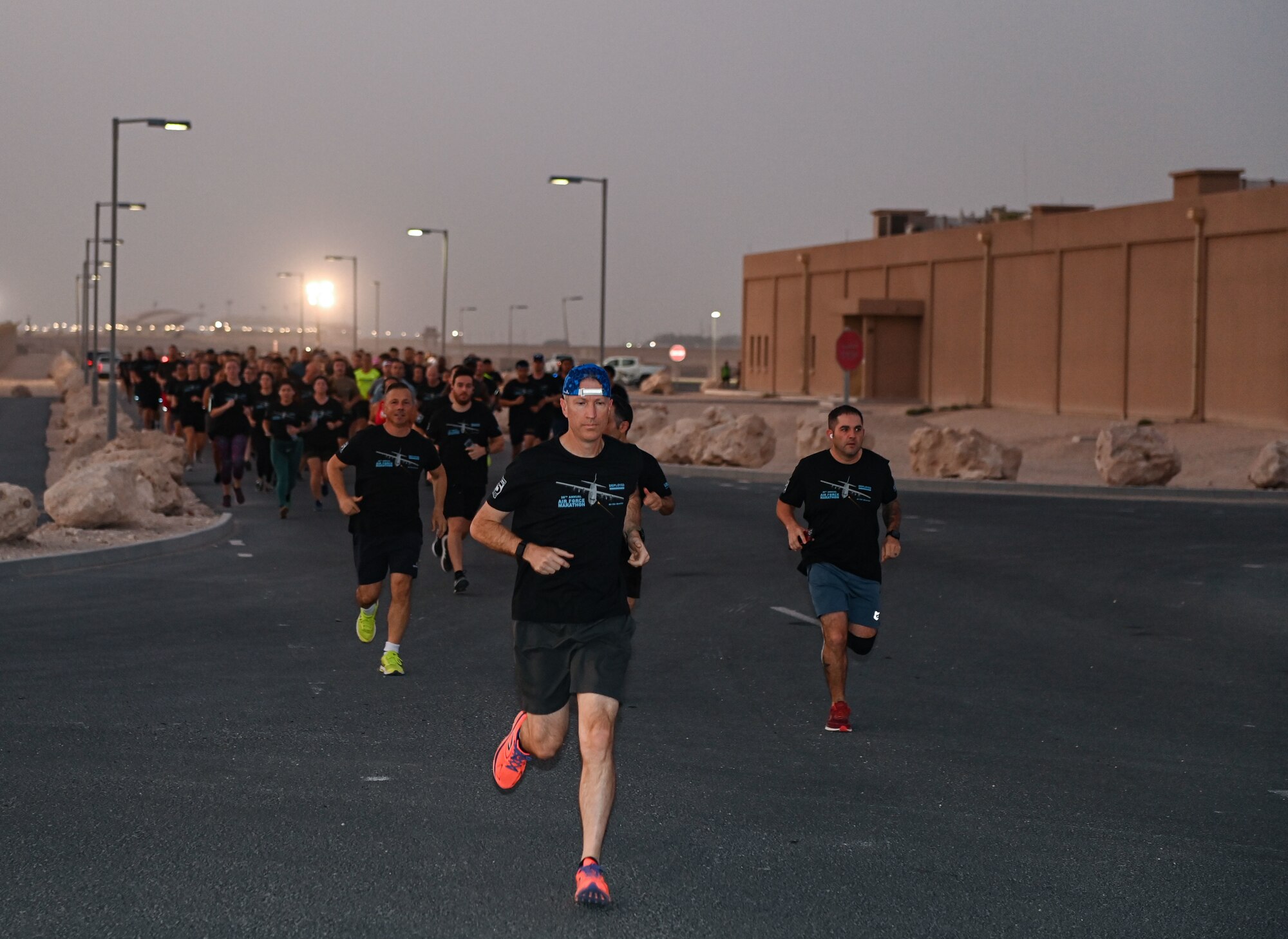 Members of Al Udeid Air Base, Qatar sprint through the start line of a morale run celebrating of the U.S. Air Force Birthday Sept. 17, 2022. The run commemorated the creation of the U.S. Air Force from the Army Air Corps 75 years ago. (U.S. Air National Guard photo by Master Sgt. Michael J. Kelly)