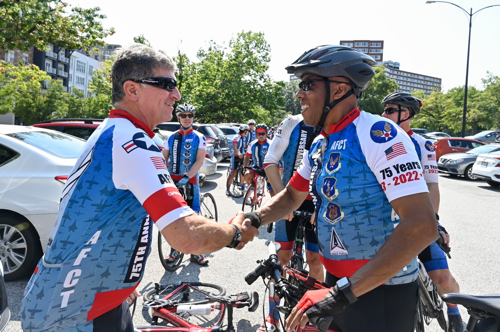 two cyclist shake hands