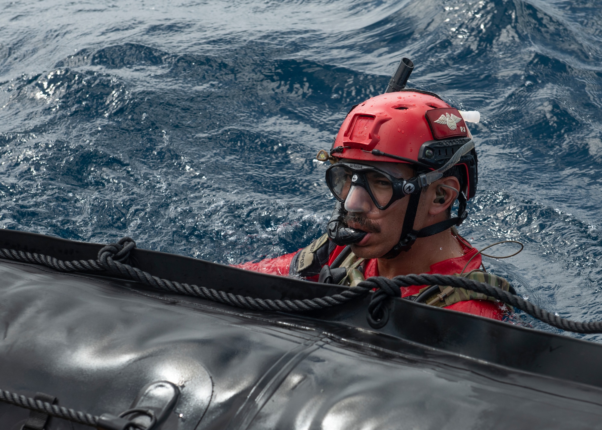 A U.S. Air Force pararescueman assigned to the 31st Rescue Squadron swims beside a combat rubber raiding craft during an amphibious search and rescue training in the Pacific Ocean, Sept. 13, 2022. PJ’s are trained, equipped and postured to conduct full spectrum personnel recovery operations in both peacetime and combat environments. (U.S. Air Force photo by Senior Airman Jessi Roth)