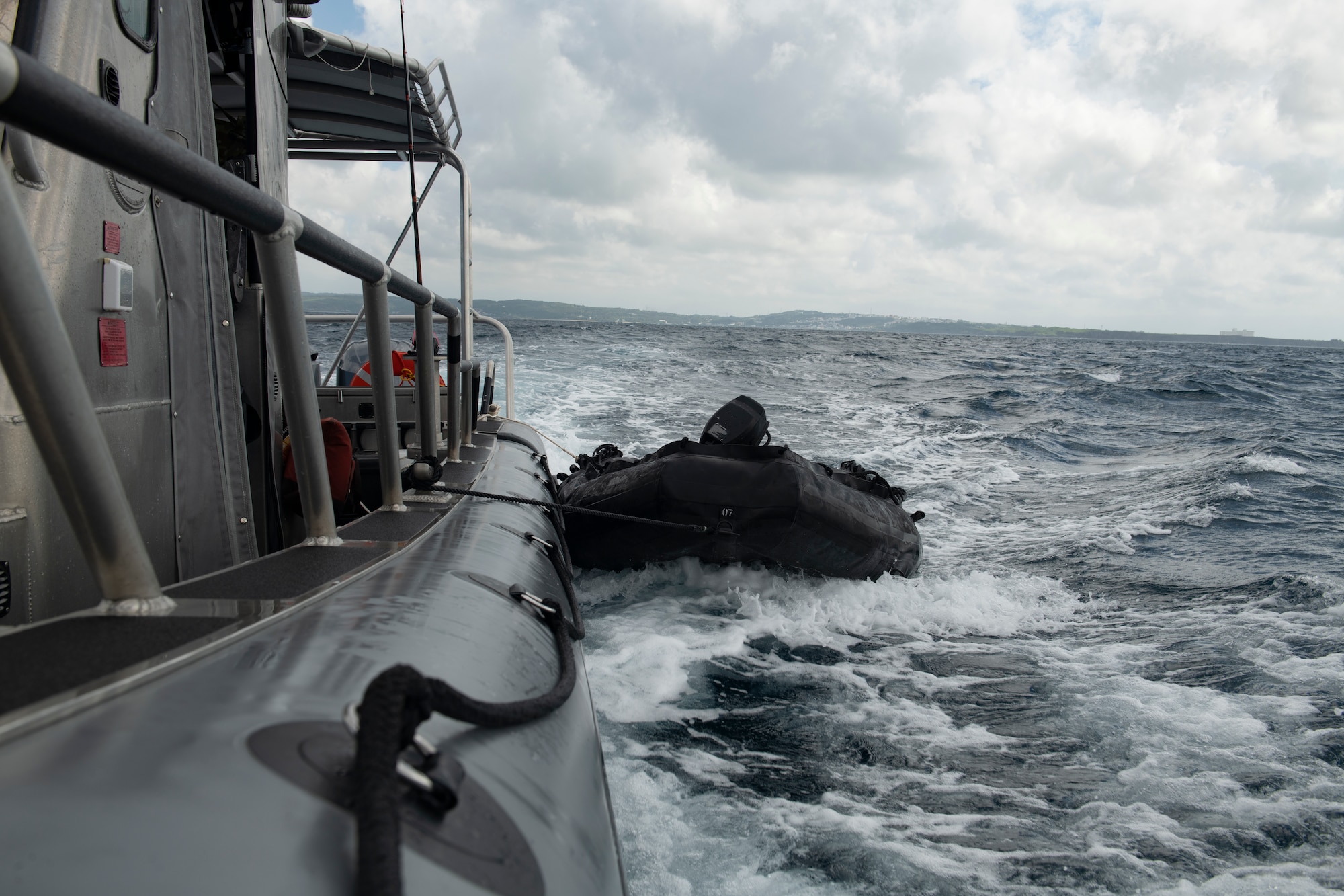 A combat rubber raiding craft is towed alongside the safe boat after the completion of a search and rescue exercise in the Pacific Ocean, Sept. 13, 2022. The training was conducted to enhance alternate insertion and extraction method capabilities, ensuring RQS personnel are ready to rapidly respond at a moment's notice. (U.S. Air Force photo by Senior Airman Jessi Monte)
