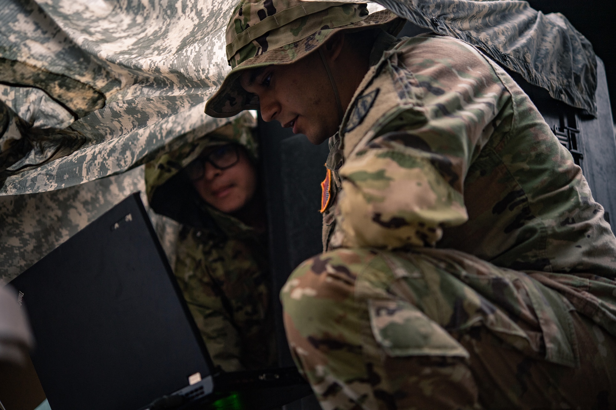 U.S. Army Pfc. Joseph Abeyta, 44th Expeditionary Signal Battalion enhanced satellite communications system operator and maintainer, left, and Spc. Kuri Marquez 44th Expeditionary Signal Battalion nodal systems operator, maintainer and integrator,  monitor the spectrum analyzer