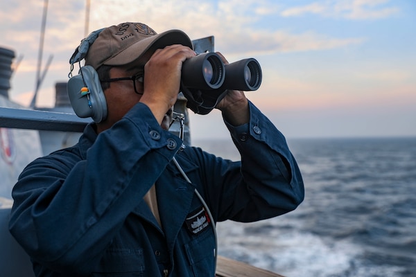 TAIWAN STRAIT (Sept. 20, 2022) Boatswain’s Mate Seaman Joseph Dumas, from West Palm Beach, Florida, identifies contacts while standing lookout watch on the bridge wing of the guided-missile destroyer USS Higgins (DDG 76) as the ship conducts routine Taiwan Strait transit. Higgins is forward-deployed to the U.S. 7th Fleet area of operations in support of a free and open Indo-Pacific. (U.S. Navy photo by Mass Communication Specialist 1st Class Donavan K. Patubo)