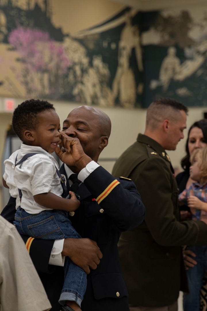 2nd Lt. Lawal Aliu holds his son during his OCS graduation in Norman, Oklahoma, Sept. 18, 2022. Aliu's first assingment as a second lieutenant will be with the 205th Signal Company, 45th Field Artillery Brigade, Oklahoma Army National Guard. (Oklahoma National Guard photo by Spc. Haden Tolbert)
