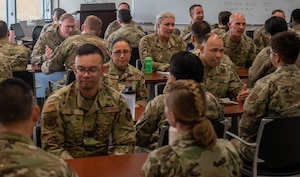 A group of people in military uniforms sitting at tables.
