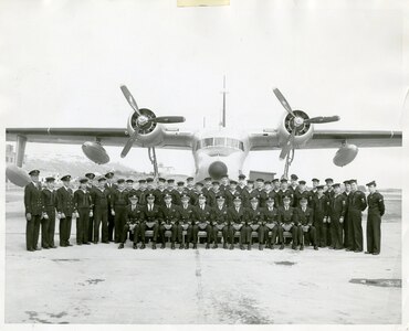 Personnel from CG Air Station Kodiak muster in front of one of the station's Grumman HU-16E Albatrosses.