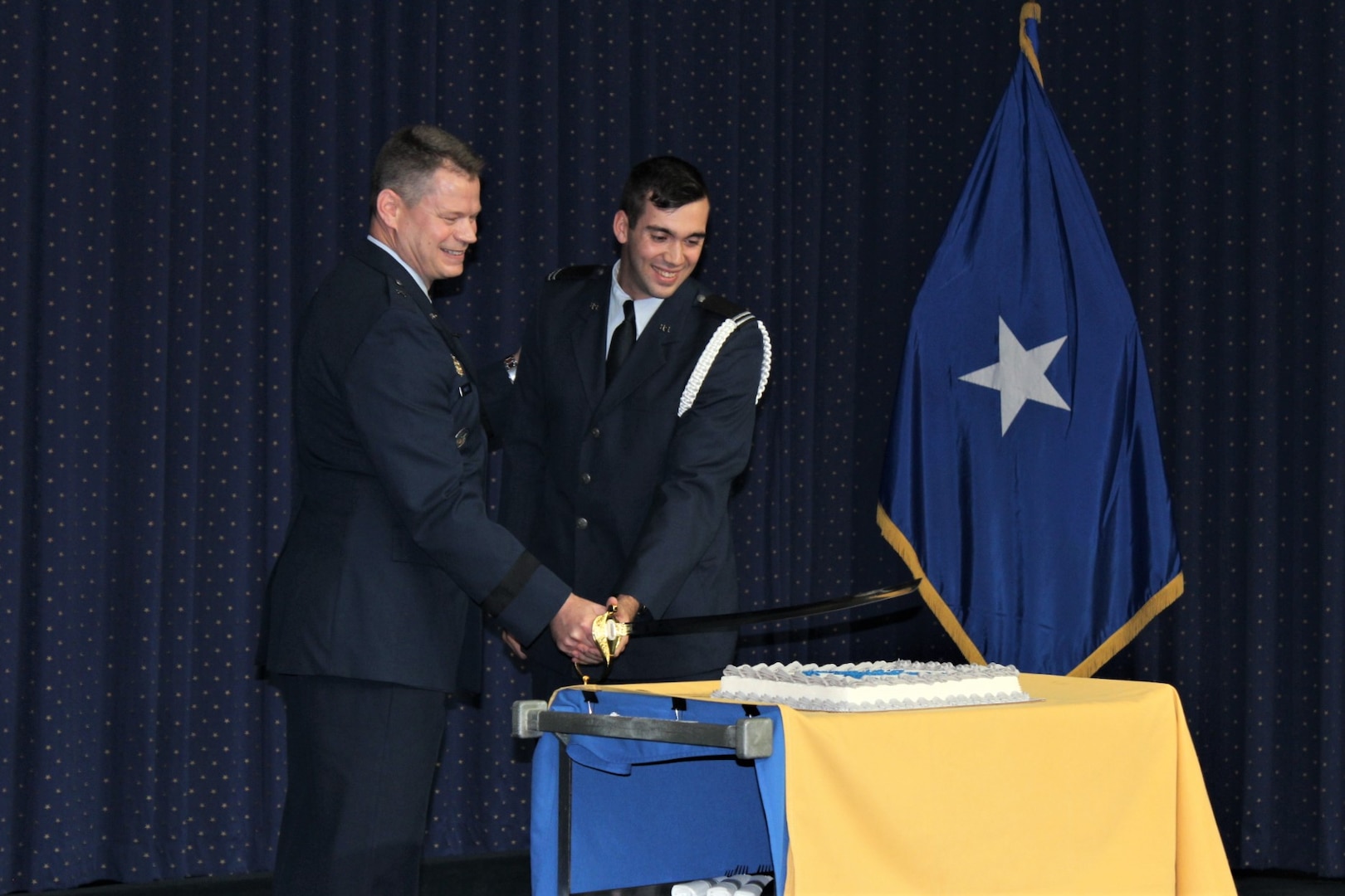 Two Air Force airmen cut a birthday cake